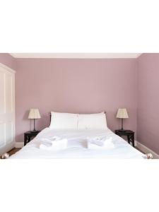 ein Schlafzimmer mit einem großen weißen Bett mit zwei Lampen in der Unterkunft Bright & Beautiful Period Property - Pass the Keys in York