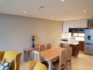 a kitchen and dining room with a table and chairs at 203 zimbali suites in Ballito