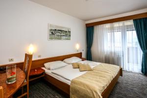 a hotel room with a bed and a table at Hotel Dražica - Hotel Resort Dražica in Krk