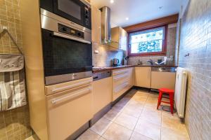 a kitchen with stainless steel appliances and a red stool at Grand appt vue Mont Blanc in Chamonix