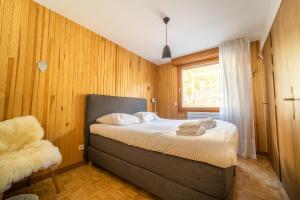 um quarto com uma cama, uma janela e uma cadeira em Grand appt vue Mont Blanc em Chamonix-Mont-Blanc