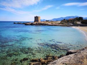 a view of a beach with a castle in the distance at Villa Porto Rais in Carini