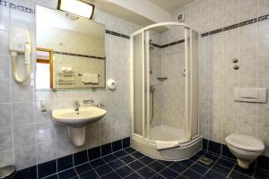 a bathroom with a sink and a shower and a toilet at Hotel Dražica - Hotel Resort Dražica in Krk