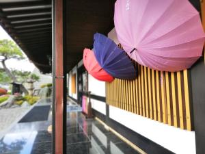 dos sombrillas colgando en un lateral de un edificio en Ishinoya Izunagaoka, en Izunokuni