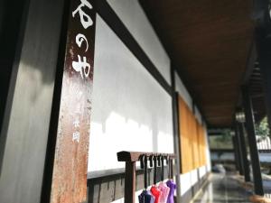 a building with a fence with writing on it at Ishinoya Izunagaoka in Izunokuni