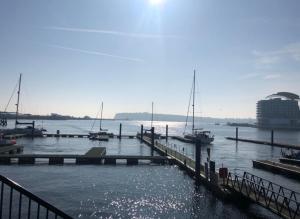 a dock with boats in a body of water at Quayside Apartment in Cardiff Bay in Cardiff