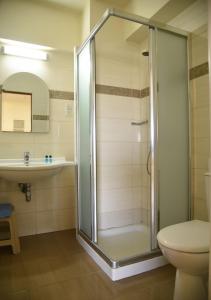 a bathroom with a shower and a toilet and a sink at Elysso Hotel in Larnaca