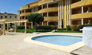 a building with a swimming pool in front of a building at Apartamento Playa las Marinas in Denia