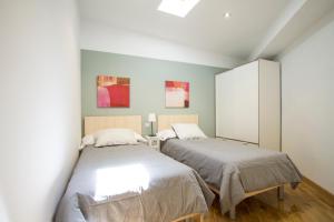 マドリードにあるApartamentos Goyescas Decoの白い壁のベッドルーム1室(ベッド2台付)