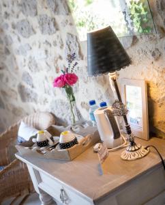 une table avec une lampe et un vase de fleurs sur elle dans l'établissement Chambres d'hôtes Larroquinière, à Port-Sainte-Marie