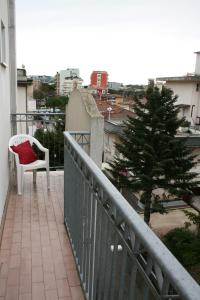 un balcone con sedia e albero su un edificio di Residenza Manuela a Riccione