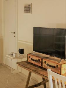 Une télévision à écran plat est installée au-dessus d'une table en bois. dans l'établissement Il Contado -room and breakfast-, à Castelfranco Emilia