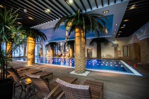 a pool with chairs and palm trees in a building at Hostel "As in europe" in Belgorod