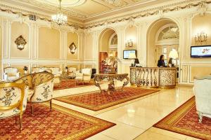 eine große Lobby mit einem Tisch und Stühlen in einem Gebäude in der Unterkunft Grand Hotel Continental in Bukarest