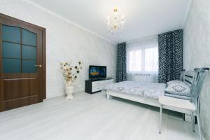 sypialnia z łóżkiem, telewizorem i drzwiami w obiekcie 1 вулиця Софії Русової w Kijowie