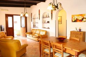 a living room with a wooden table and chairs at Villa Porto Rais in Carini