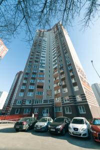 wysoki budynek z samochodami zaparkowanymi przed nim w obiekcie 1 вулиця Софії Русової w Kijowie