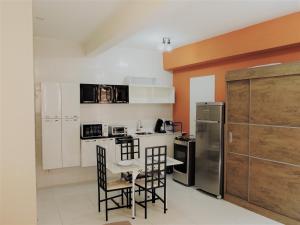a kitchen with a table and chairs and a refrigerator at 10 Studios in Sao Paulo