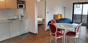 - une cuisine et une table avec des chaises dans la chambre dans l'établissement Médicis Home Strasbourg, à Strasbourg