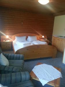 1 dormitorio con cama grande de madera y sofá en Haus Karwendelblick, en Leutasch