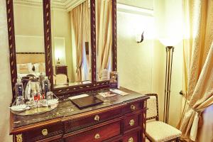 a large mirror sitting on top of a wooden dresser at Grand Hotel Continental in Bucharest