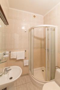 La salle de bains est pourvue d'une douche, d'un lavabo et de toilettes. dans l'établissement Zhayvir, à Kiev