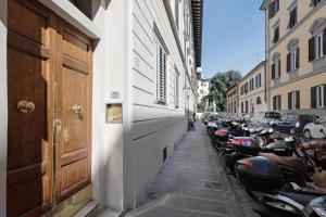 une rangée de motocycles garés sur le côté d'une rue dans l'établissement Giardino della Fortezza Apartment, à Florence