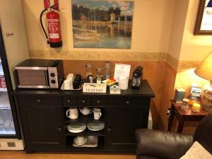 a black cabinet with a coffee maker and a microwave at Hotel Bahia in Gijón