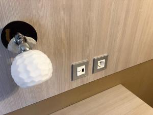 a light on a wall with two light switches at Hotel Bahia in Gijón +29 photos