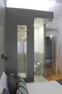 una camera con un grande specchio e un letto di GoodTime Marquês Suites a Lisbona