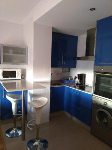 une cuisine avec des placards bleus et un comptoir dans l'établissement Cambados Apartamento VUT-PO-TU986D, à Cambados