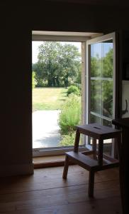 a window with a bench in front of a door at La Grange au Manoir in Le Manoir