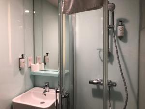 a white bathroom with a sink and a shower at easyHotel Birmingham in Birmingham +28 photos