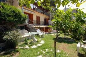 einen Garten mit einem Tisch und einer Bank vor einem Gebäude in der Unterkunft Casa Stella Marina in Praiano