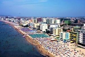 a beach with many umbrellas and crowds of people at Fati Guest House in Durrës