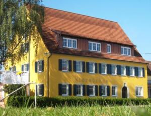 un edificio amarillo con techo rojo en Klozbücher - Das Landhotel, en Ellwangen