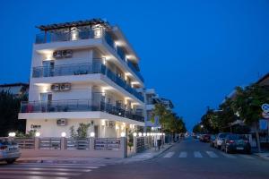 a tall white building on a city street at night at Olympic Coast in Olympic Beach