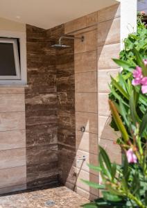a shower in a bathroom with a wooden wall at Olympic Coast in Olympic Beach