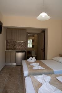 two beds in a room with a kitchen at Olympic Coast in Olympic Beach