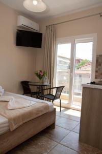a bedroom with a bed and a table and a balcony at Olympic Coast in Olympic Beach