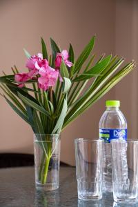 a table with two glasses and a bottle of water and flowers at Olympic Coast in Olympic Beach