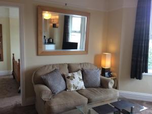 a living room with a couch and a mirror at Parkview Apartments in High Wycombe