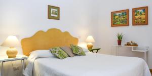 a bedroom with a white bed with two tables and two lamps at Masseria GiòSole in Capua