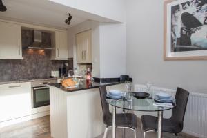 a kitchen with a table with chairs and a counter top at Tethera at Coal Yeat in Spark Bridge +22 photos