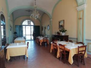 a dining room with tables and chairs and a chandelier at Locanda Corte Roveri in Bologna