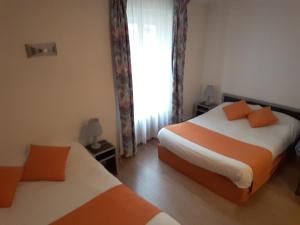 1 dormitorio con 2 camas y ventana en Logis de la Barque, en Beaumont-sur-Sarthe