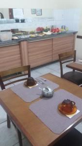 a table with two chairs and a counter with food at Hotel Central Rosário in Jundiaí