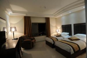 a hotel room with two beds and two lamps at Tetra Tree Hotel in Wadi Musa