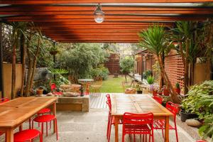 un patio con mesa de madera y sillas rojas en Pensao Favorita, en Oporto