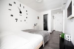 1 dormitorio con 1 cama y reloj en la pared en Stunning Studio By The Beach With Free Parking, en Tel Aviv